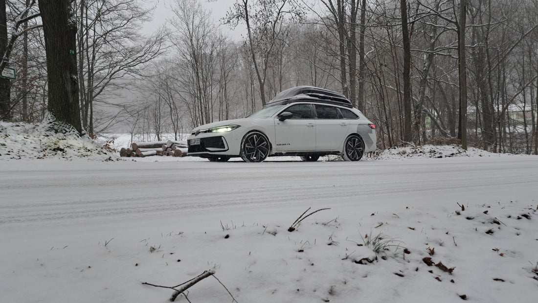 Auto mit wyde pack Dachbox in einer Schnee bedeckten Landschaft