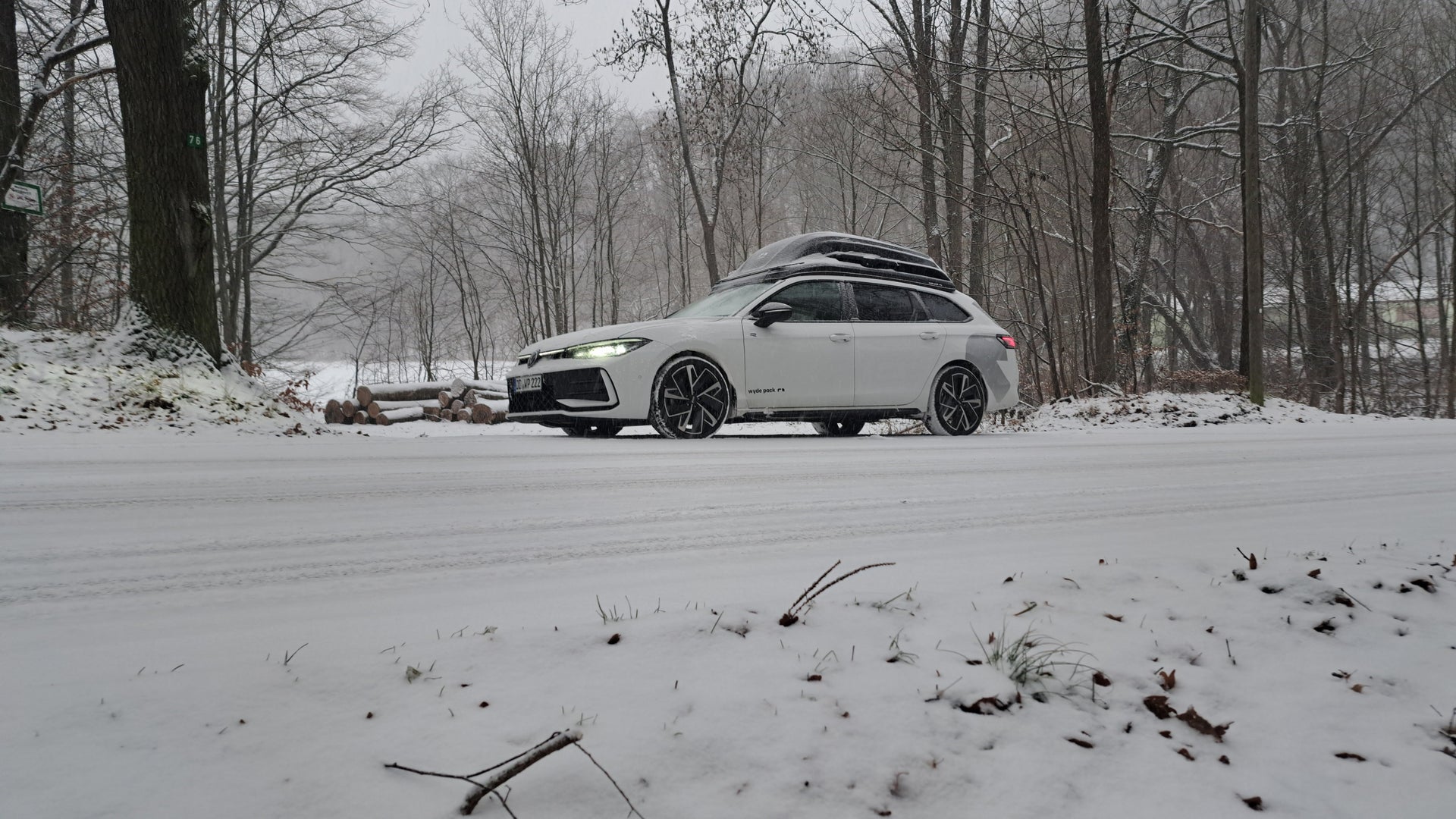 Auto mit wyde pack Dachbox in einer Schnee bedeckten Landschaft